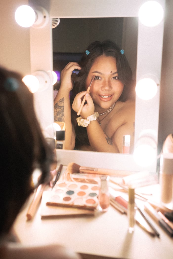 Girl Applying Makeup in Front of Vanity Mirror